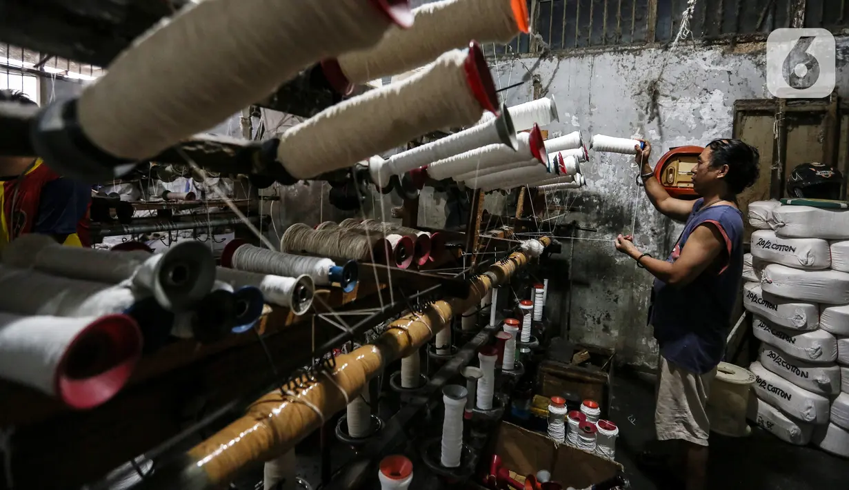 Pekerja memintal benang di Kebayoran, Jakarta, Selasa (5/7/2022). Pabrik benang yang berdiri sejak tahun 1970-an tersebut dapat memproduksi 100 kilogram benang dalam sehari dan dipasarkan ke berbagai daerah di Indonesia. (Liputan6.com/Johan Tallo)