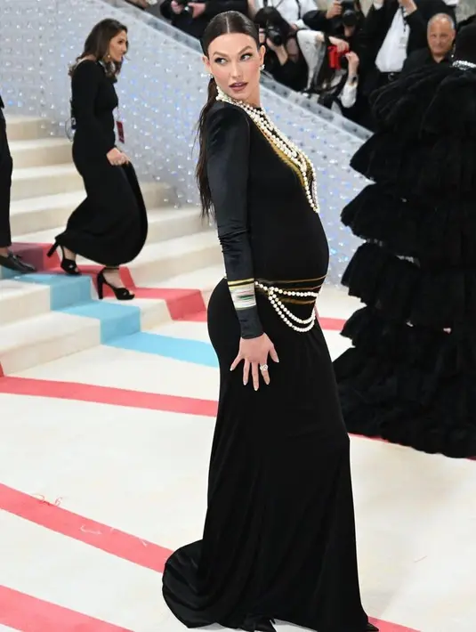 Di area gold pada dress juga diselubungi dengan kalung mutiara. Ia pun menata rambut panjang dengan ikat ponytail. [@themetgalaofficial]