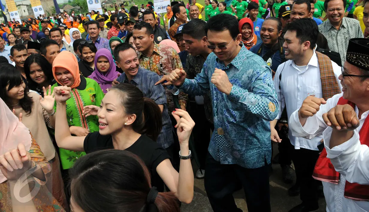 Gubernur DKI Jakarta Basuki Tjahaja Purnama (tengah) berjoget saat kegiatan "Gerakan Satu Hati Bangun Komunitas Harapan Indonesia", Jakarta, (5/3). Kegiatan bertujuan menginspirasi semua pihak ikut serta dalam proyek rusunawa. (Liputan6.com/Helmi Afandi)