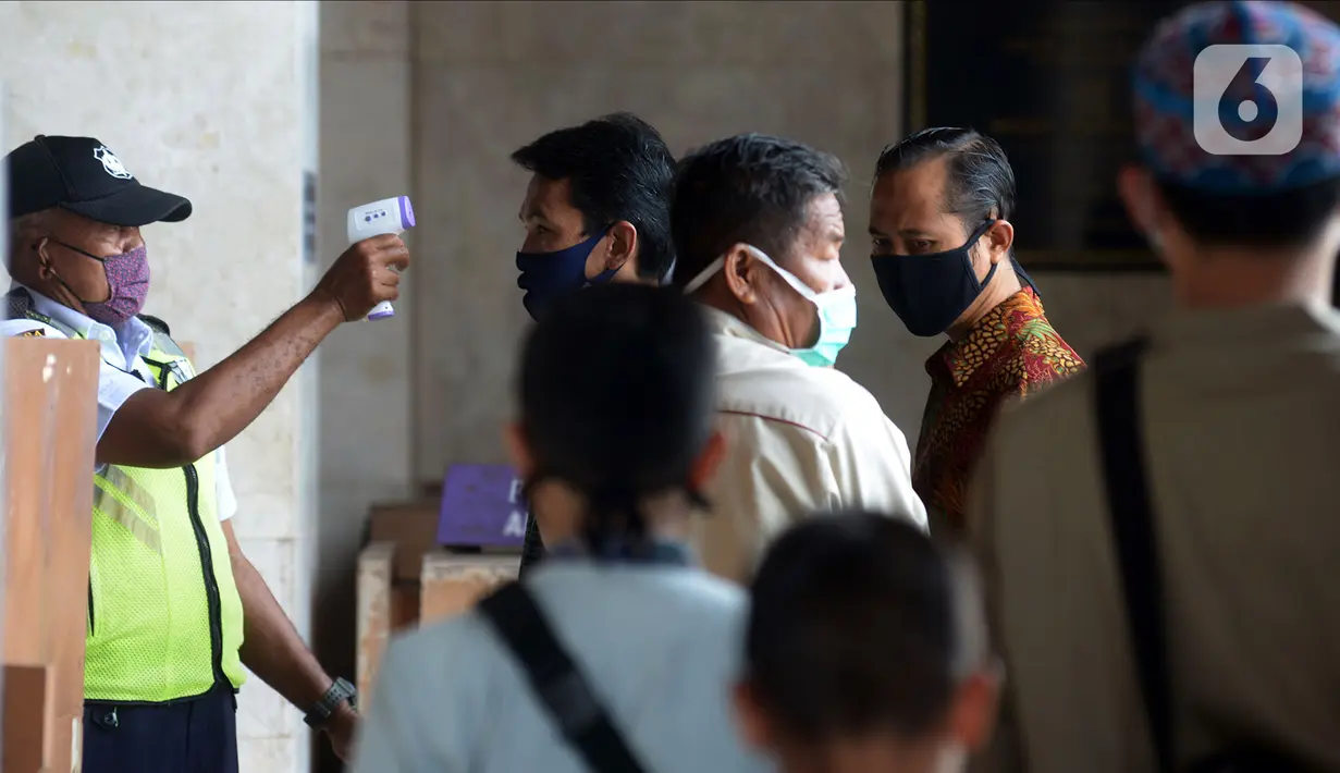 Petugas memeriksa suhu tubuh jemaah saat pelaksanaan ibadah salat Jumat di Masjid Agung At-Tin, Jakarta, Jumat (5/6/2020). Sejumlah masjid di Jakarta menggelar salat Jumat karena sudah memasuki masa PSBB transisi menuju new normal. (merdeka.com/Imam Buhori)