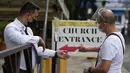 Seorang pria menunjukkan kartu vaksinnya untuk memasuki Gereja Santo Domingo saat kegiatan keagamaan dibuka kembali di kota Quezon, Filipina, Kamis (16/9/2021). Pemerintah memulai uji coba lockdown granular, di mana pembatasan ketat diterapkan untuk area yang lebih kecil. (AP/Aaron Favila)