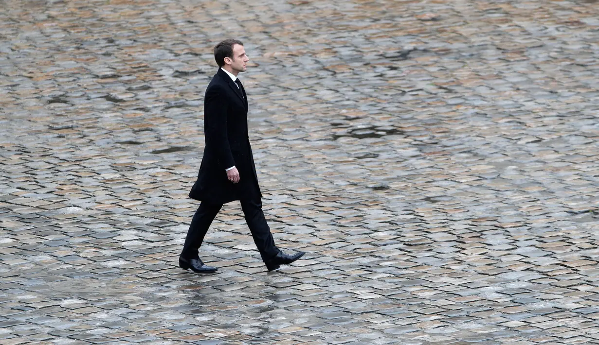 Presiden Prancis, Emmanuel Macron memimpin upacara pemakaman nasional Letnan Kolonel Arnaud Beltrame di Hotel des Invalides, Paris, Rabu (28/3). Macron pun memberikan penghargaan perwira tertinggi bagi Beltrame, Legiun d'Honneur. (AP/Christophe Ena)