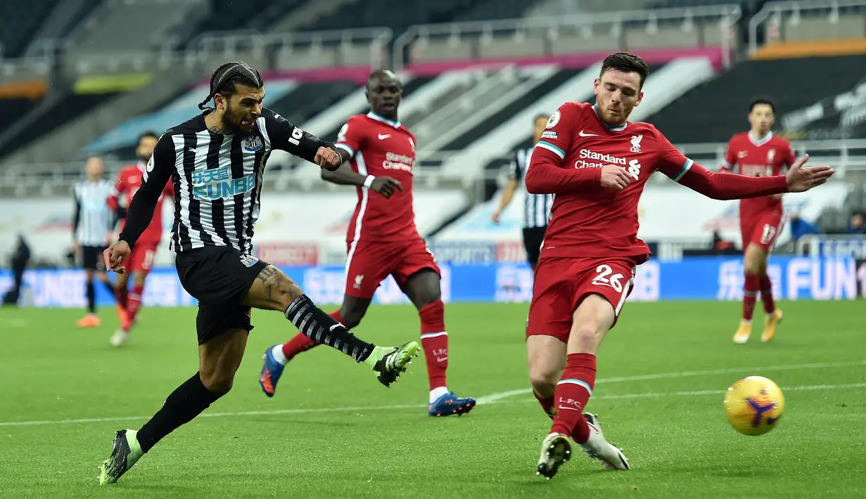 Bek Newcastle United, DeAndre Yedlin (kiri) melepaskan tendangan dibayangi bek Liverpool, Andrew Robertson dalam laga lanjutan Liga Inggris 2020/21 pekan ke-16 di St James' Park, Rabu (30/12/2020). Newcastle United bermain imbang 0-0 dengan Liverpool. (AFP/Peter Powell/Pool)
