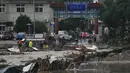 Penduduk desa berkumpul di dekat jalan runtuh yang rusak akibat banjir di Distrik Mentougou saat hujan terus menerus memicu peringatan di Beijing, Senin, 31 Juli 2023. (AP Photo/Andy Wong)