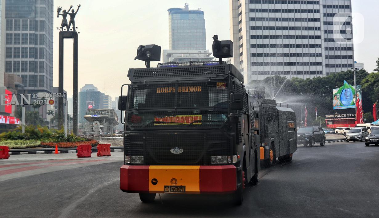 Kendaraan water canon Brimob Polda Metro Jaya menyemprotkan air di kawasan Bundaran HI, Jakarta, Rabu (23/8/2023). Pemerintah Provinsi (Pemprov) DKI Jakarta dan Polda Metro Jaya melakukan penyemprotan air di sepanjang Jalan Medan Merdeka Barat hingga Patung Pemuda Membangun Senayan sebagai upaya untuk mengurangi polusi udara dan mengatasi cuaca panas di Ibu Kota. (Liputan6.com/Angga Yuniar)