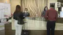 Petugas melayani pengunjung yang akan menginap di Hotel Grand Whiz Poins Simatupang, Jakarta, Kamis (16/4/2020). Di tengah pandemi virus corona COVID-19, hotel ini menyediakan paket isolasi mandiri selama 14 hari dengan harga Rp 6.500.000. (merdeka.com/Dwi Narwoko)
