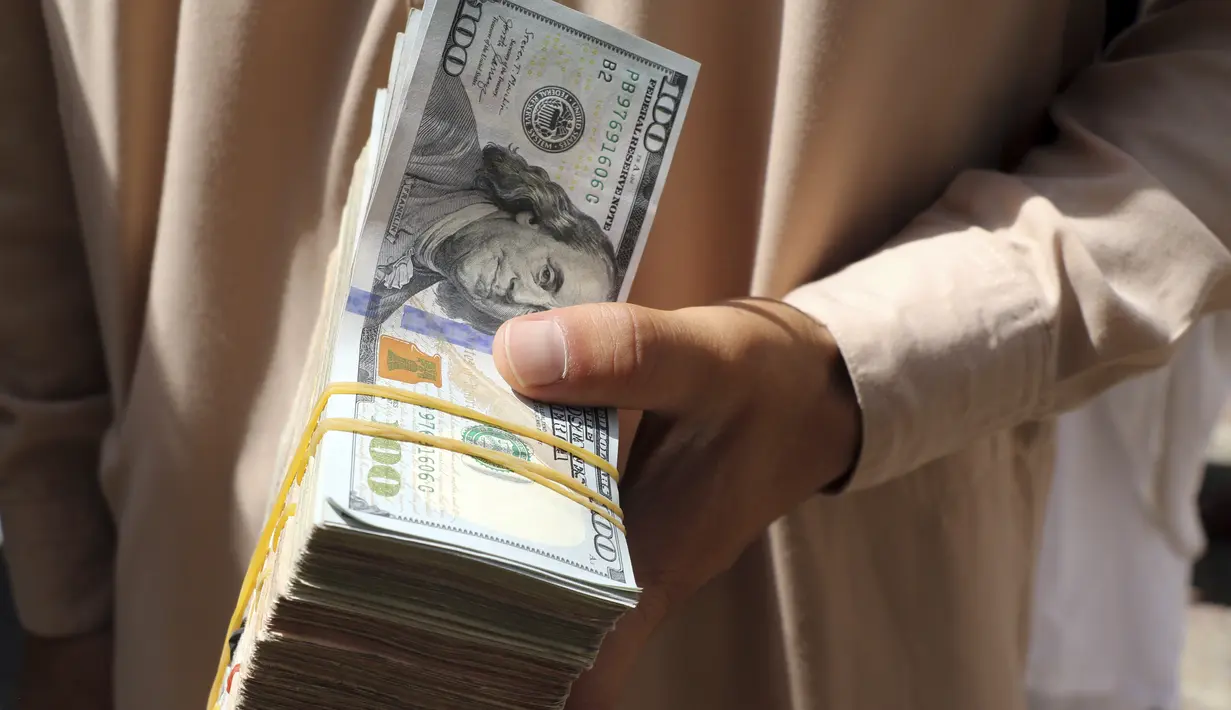 Seorang pedagang penukaran uang Afghanistan menunggu pelanggan di pasar Sarai Shahzada, menyusul pembukaan kembali bank dan pasar setelah Taliban mengambil alih kekuasaan di Kabul, pada Sabtu (4/9/2021). (AP Photo/Wali Sabawoon)