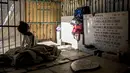 Seorang gadis beristirahat di tempat perlindungan darurat di Pemakaman Umum Selatan di Caracas, pada 10 Februari 2021. Makam yang dirusak telah menjadi rumah bagi banyak tunawisma di Venezuela. (Pedro Rances Mattey / AFP)