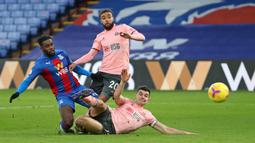 Gelandang Crystal Palace, Jeffrey Schlupp (kiri) melepaskan tendangan yang berbuah gol pertama timnya ke gawang Sheffield United dalam laga lanjutan Liga Inggris 2020/21 pekan ke-17 di Selhurst Park, Sabtu (2/1/2021). Crystal Palace menang 2-0 atas Sheffield United. (AFP/Catherine Ivill/Pool)