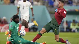 Kiper Ghana Lawrence Ati-Zigi melakukan penyelamatan dari tembakan penyerang Portugal Cristiano Ronaldo pada duel grup H Piala Dunia 2022 di stadion 974, Kamis (24/11/2022). Ronaldo kini menjadi pemain pertama dalam sejarah yang mencetak gol di lima Piala Dunia.  (AP Photo/Darko Bandic)