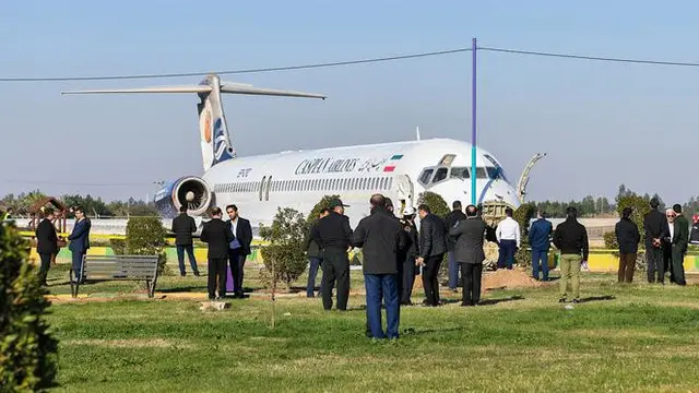 Petugas dan warga melihat kondisi pesawat Caspian usai tergelincir hingga berhenti di tengah jalan raya di Kota Bandar-e Mahshahr, Iran (27/1/2020).