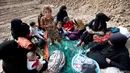 Sejumlah perempuan dan anak-anak Irak duduk di dekat tanggul setelah melarikan diri dari desa dikuasai ISIS, Irak, Senin (31/10). (REUTERS / Azad Lashkari )