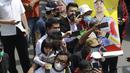 Seorang anak digendong orang tuanya saat melihat parade pembalap MotoGP di depan Sarinah Thamrin, Jakarta Pusat. Sebanyak 20 pembalap melakukan parade motor dari Istana Merdeka menuju Hotel Kempinski di Bundaran HI Jakarta Pusat, Rabu (16/03/2022). (Bola.com/M Iqbal Ichsan)