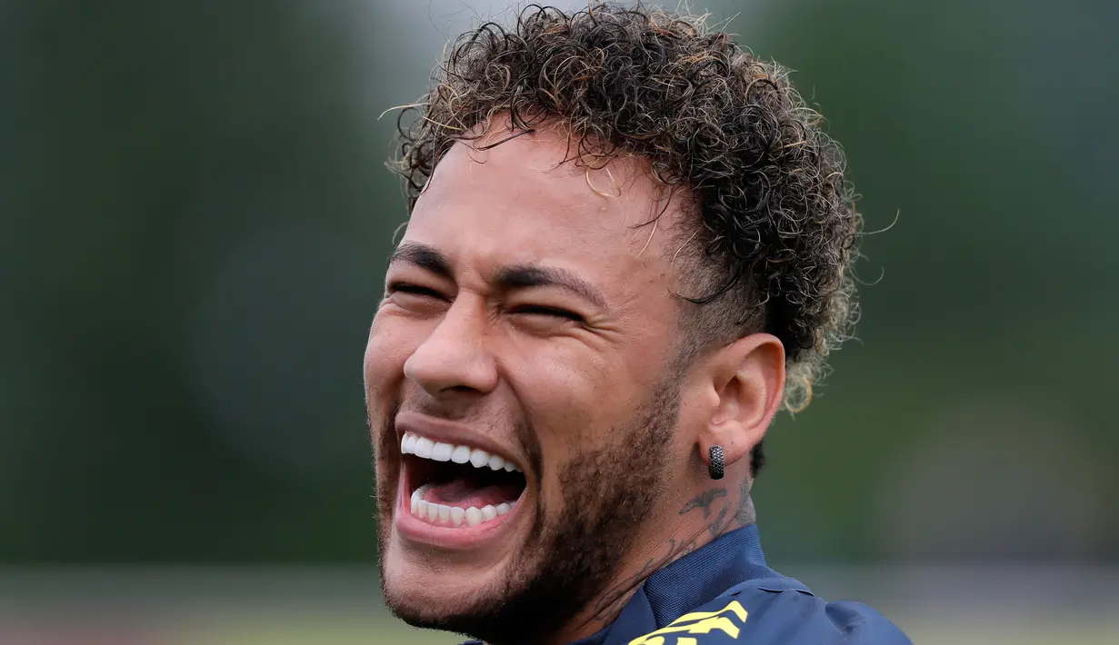Pemain timnas Brasil Neymar tertawa saat mengikuti sesi latihan di London, Inggris (29/5). Neymar dan rekan-rekannya melakukan latihan jelang pertandingan persahabatan melawan Kroasia. (AP / Kirsty Wigglesworth)