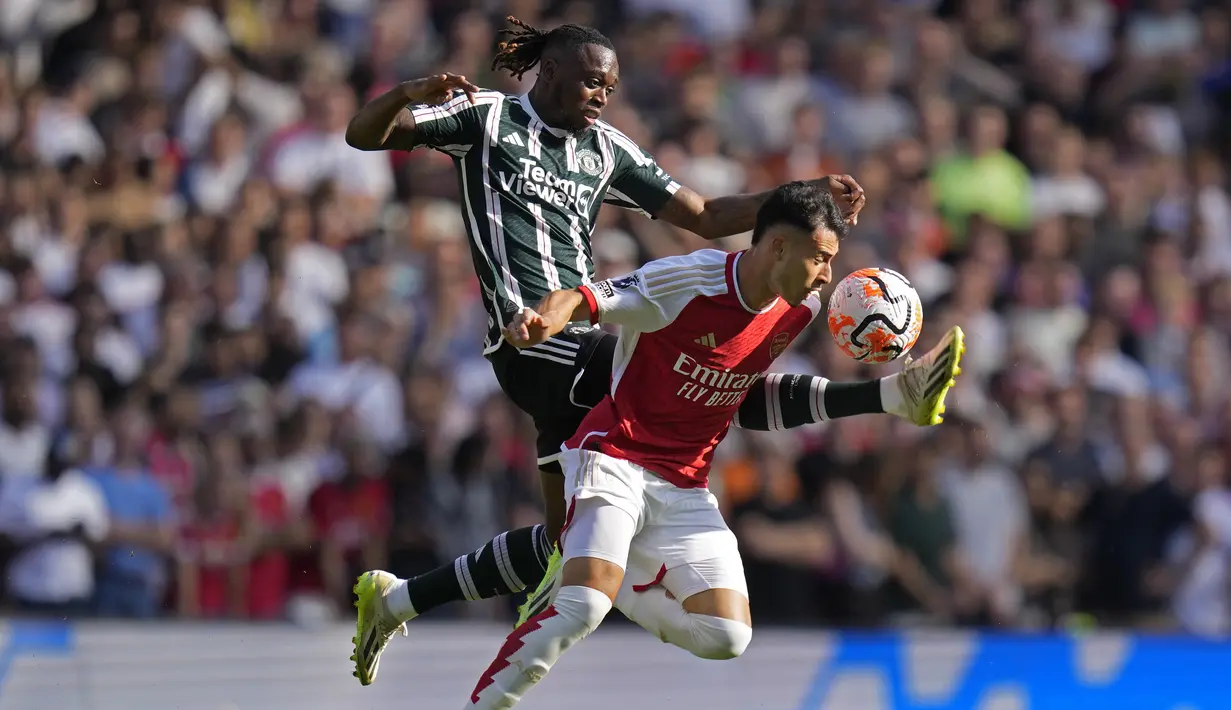 Bek Manchester United (MU) Aaron Wan-Bissaka berebut bola dengan penyerang Arsenal Gabriel Martinelli pada pekan keempat Liga Inggris 2023/2024 di Emirates Stadium, Minggu (3/9/2023) waktu setempat. (AP Photo/Kirsty Wigglesworth)