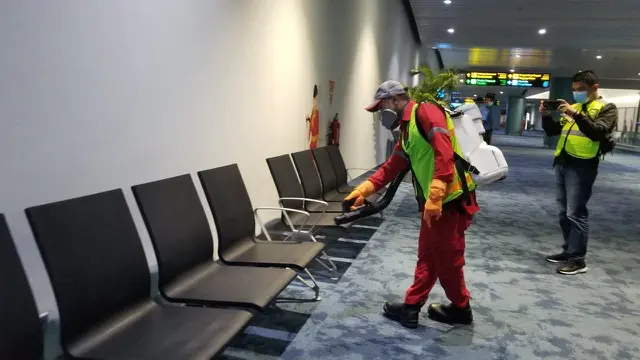 Pengelola Bandara Internasional Soekarno Hatta, PT Angkasa Pura II (AP II), menyemprotkan cairan disinfektan di  Terminal 2 dan Terminal 3 Kedatangan Internasional, Kamis (5/3/2020) dini hari.