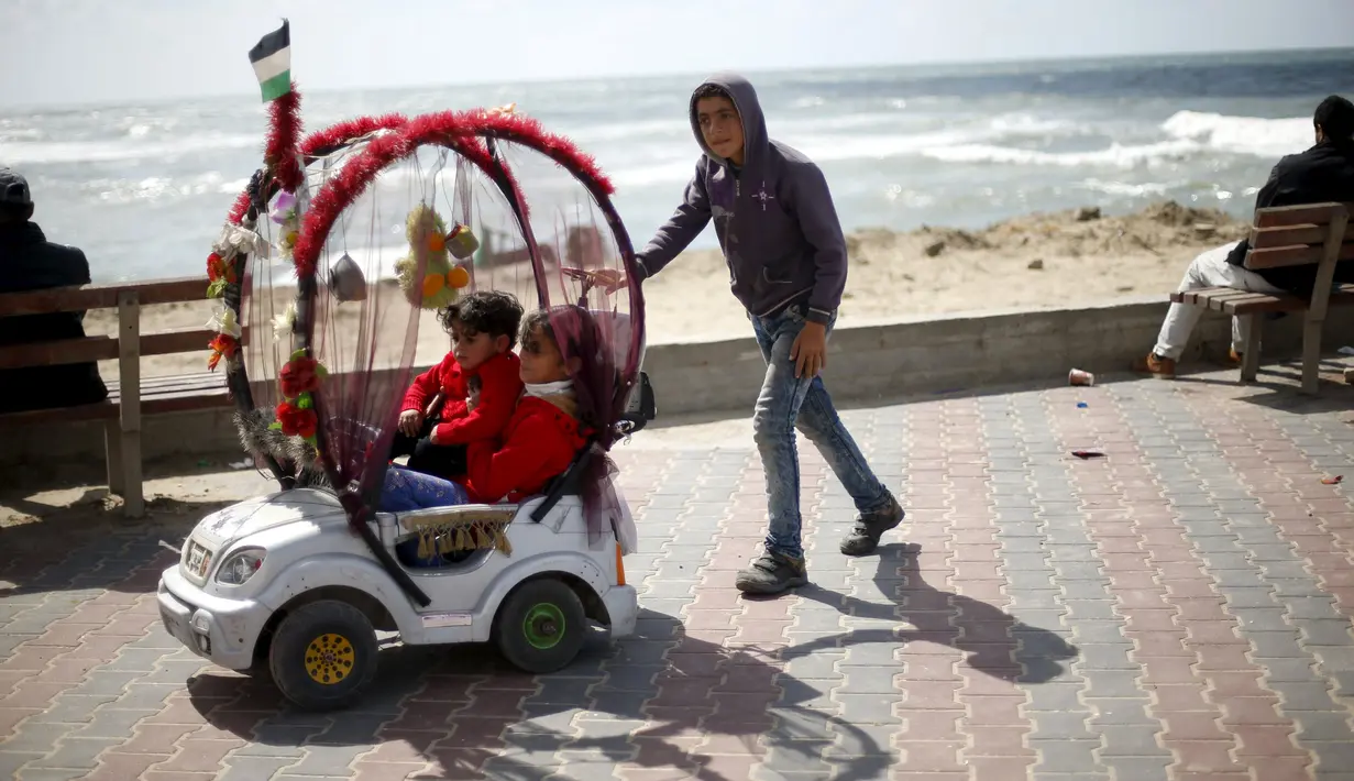 Mahand Salama (13), bocah Palestina menyewakan mobil mainan bagi anak-anak di Pelabuhan Kota Gaza (17/3). Salama yang mempunyai cita-cita menjadi dokter ini menghasilkan sekitar 25 Shekels ( $ 6.4) per hari kerja. (REUTERS/Mohammed Salem)