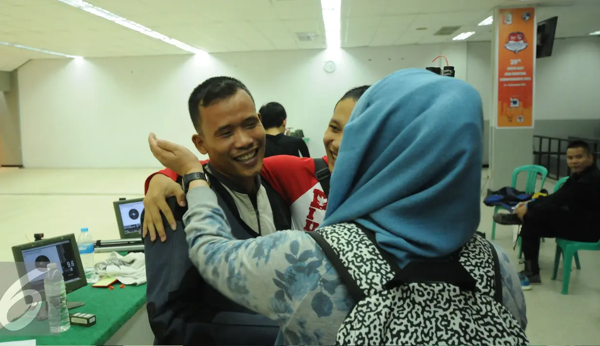 Petembak Indonesia, M Hasan Busri dipeluk rekan setimnya usai memastikan meraih perak 39th South East Asia Shooting Championships kelas 10m Air Rifle Men di Jakarta, Kamis (19/11/2015). Hasan mencatat 200,2poin. (Liputan6.com/Helmi Fithriansyah)