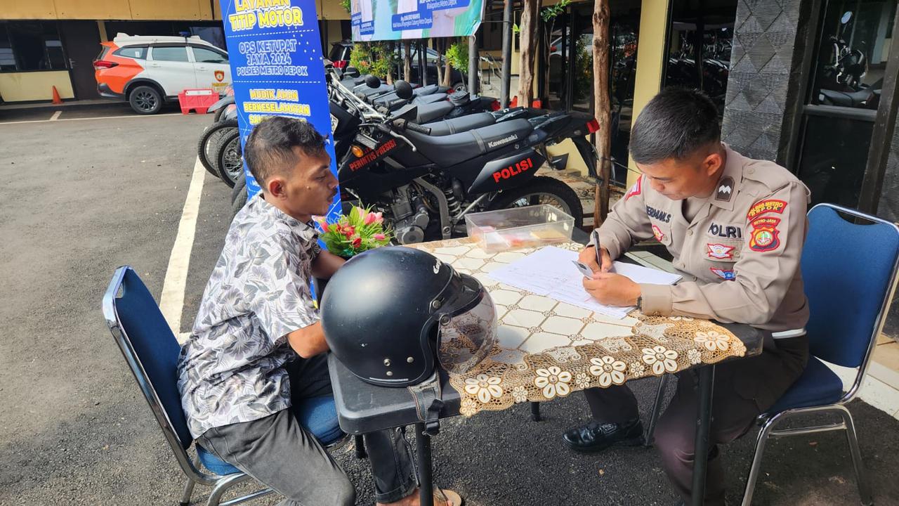 Salah seorang warga menitipkan kendaraan bermotor di Polres Metro Depok.