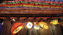 Sejumlah wanita membawa lampion beraneka bentuk saat Lotus Lantern Festival di Seoul, Korea Selatan, Sabtu (29/4). Parade ini bagian dari jelang perayaan ulang tahun Buddha yang jatuh pada 3 Mei 2017. (AP Photo / Lee Jin-man)