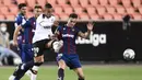 Penyerang Valencia, Rodrigo Moreno, berebut bola dengan bek Levante, Sergio Postigo, pada laga pekan ke-28 Liga Spanyol di Stadion Mestalla, Sabtu (13/6/2020) dini hari WIB. Valencia bermain imbang 1-1 atas Levante. (AFP/Jose Jordan)