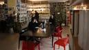Orang-orang Lebanon duduk dengan laptop mereka di sebuah kafe di Beirut pada 14 Januari 2022.	Kafe-kafe Beirut sekarang berfungsi sebagai tempat kerja pengganti bagi orang-orang yang bergulat dengan kekurangan listrik dan pemutusan internet yang berasal dari krisis ekonomi. (JOSEPH EID / AFP)
