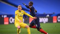 Penyerang Ukrainan Viktor Kovalenko (kiri) berjibaku melawan gelandang Prancis, Paul Pogba, pada laga kualifikas Piala Dunia 2022 di Stade de France, Kamis (25/3/2021) dini hari WIB. (AFP/Franck Fife)