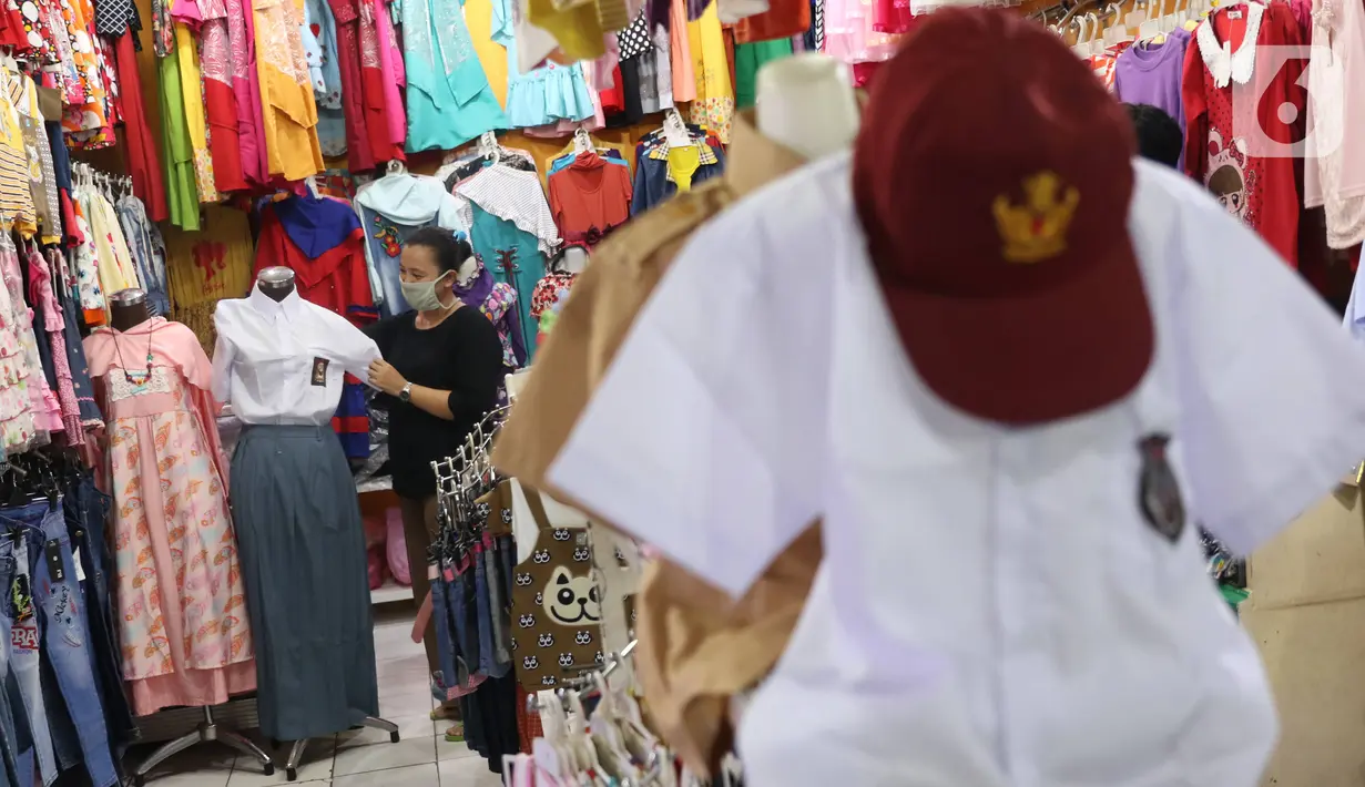 Pedagang merapikan seragam sekolah baru dagangannya di salah satu toko di Tangerang, Banten, Selasa (2/6/2020). Menjelang tahun ajaran baru, sejumlah pedagang di tempat tersebut mengeluh karena omzet penjualan seragam sekolah menurun drastis akibat pandemi COVID-19. (Liputan6.com/Angga Yuniar)