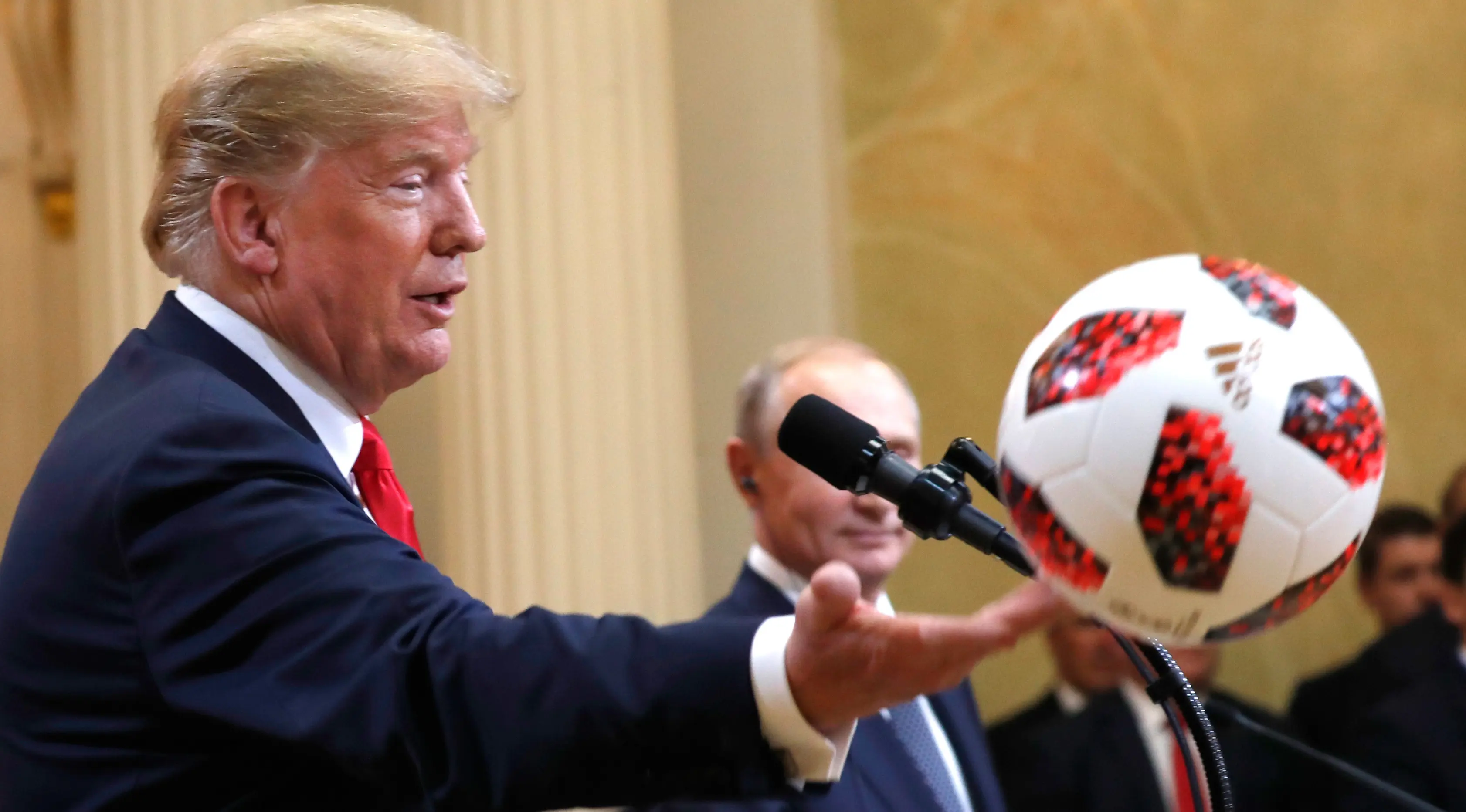 Presiden AS Donald Trump melemparkan bola ke arah Melania pada konferensi pers bersama Presiden Rusia Vladimir Putin di Helsinki, Finlandia, Senin (16/7). Bola Piala Dunia 2018 berwarna putih-merah itu diberikan oleh Putin. (AP/Pablo Martinez Monsivais)