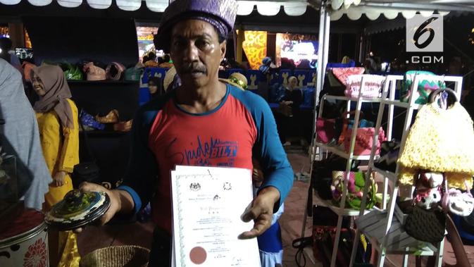 Abas, salah satu maestro permainan Gasing Melayu menunjukkan sijil (penghargaan) dari pemerintah Malaysia. (foto: Liputan6.com / ajang nurdin)