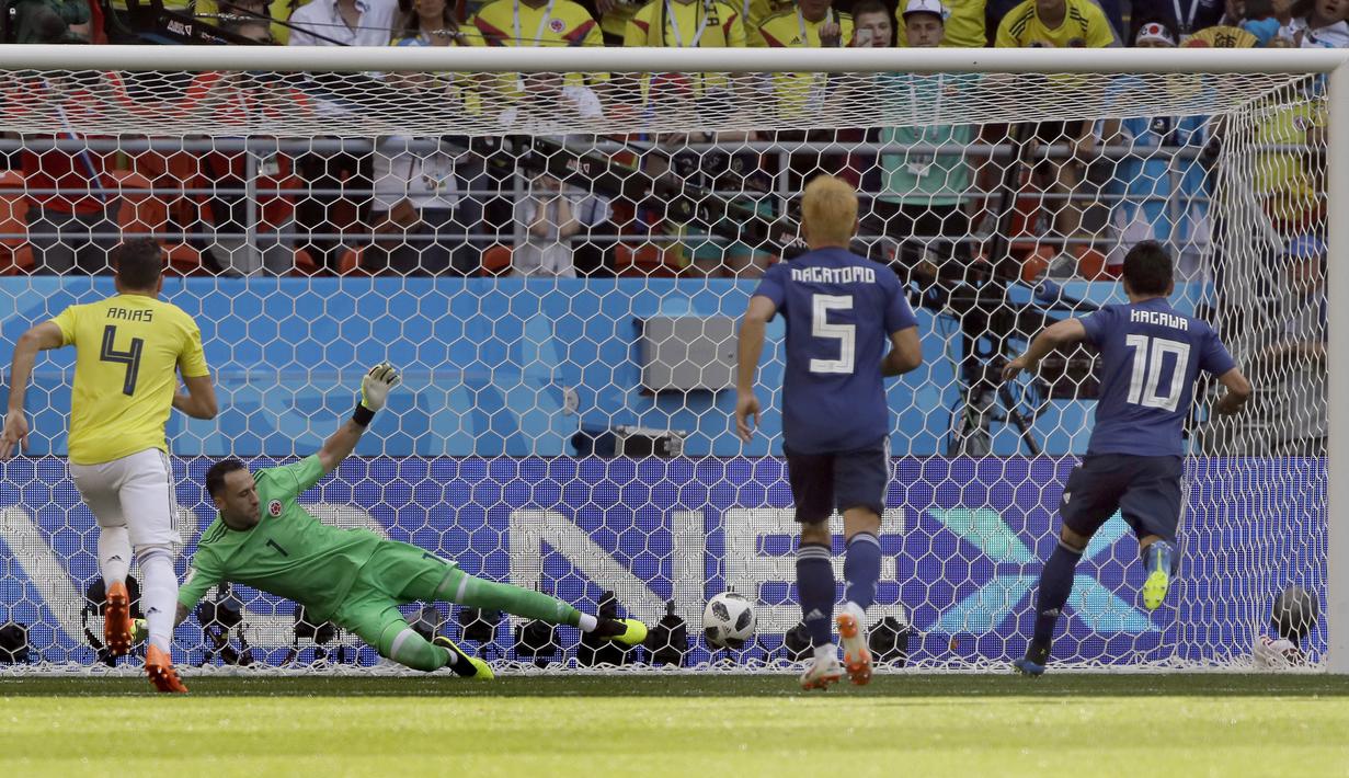 Pemain Jepang, Shinji Kagawa (kanan) mencetak gol lewati penalti ke gawang Kolombia pada laga grup H Piala Dunia 2018 Mordavia Arena, Saransk, Rusia, (19/6/2018). Jepang menang 2-1. (AP/Mark Baker)