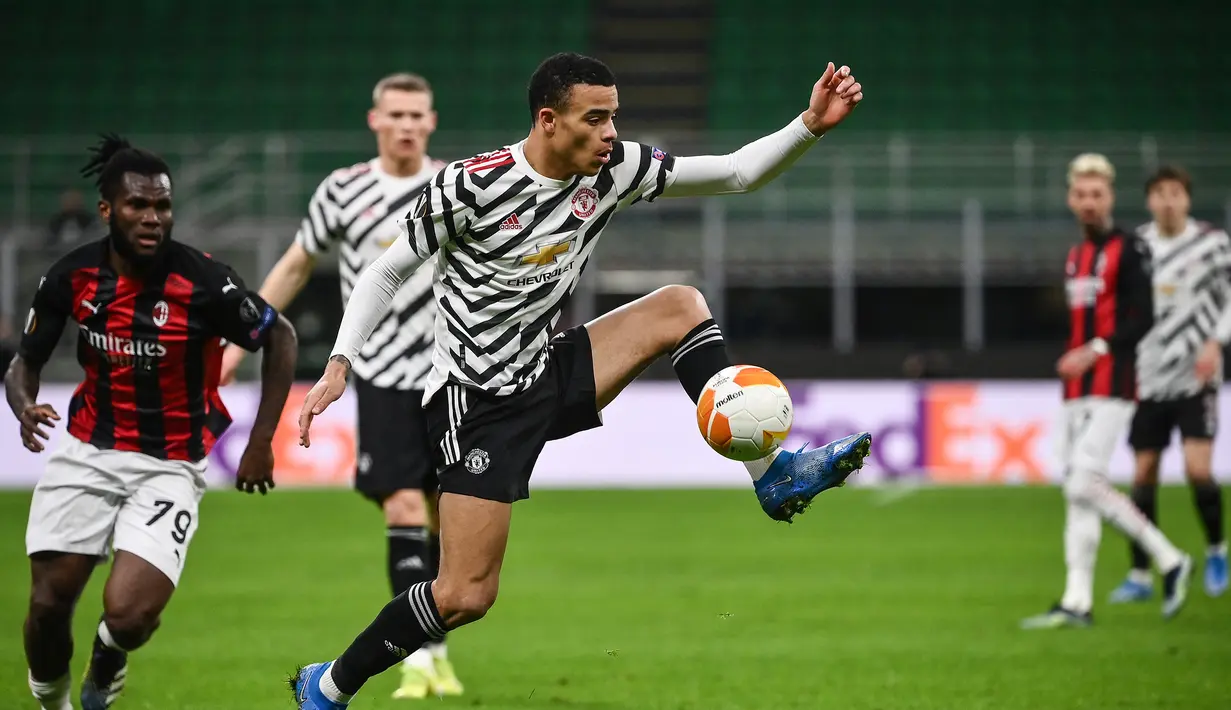 Striker Manchester United, Mason Greenwood mengontrol bola di depan gelandang AC Milan, Franck Kessie dalam laga leg kedua babak 16 besar Liga Europa 2020/2021 di San Siro Stadium, Milan, Kamis (18/3/2021). Manchester United menang 1-0 atas AC Milan. (AFP/Marco Bertorello)