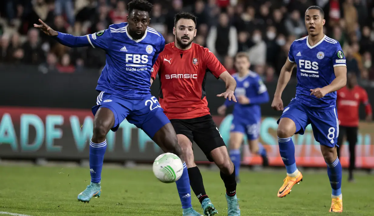 Penyerang Rennes Gaetan Laborde (tengah) berebut bola dengan bek Leicester City Ryan Bertrand pada leg kedua babak 16 besar Europa Conference League di Roazhon Park , Jumat (18/3/2022) dini hari WIB. Meski kalah 1-2, Leicester City tetap lolos ke perempat final. (AP Photo/Jeremias Gonzalez)