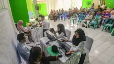 Warga saat melakukan pembuatan paspor saat kegiatan "Layanan Eazy Paspor" bagi calon jemaah haji di Pesantren Daarul Aitam, Pamulang, Tangerang Selatan, Banten, Rabu (15/10/2025). (merdeka.com/Arie Basuki)