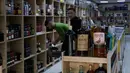 Sejumlah pembeli memilih alkohol di sebuah toko minuman keras di Baghdad, Irak, Kamis, 9 Maret 2023. Dalam sebuah pernyataan, Otoritas Umum Bea Cukai Irak mengatakan seluruh titik pabean diperintahkan melarang masuk segala jenis minuman beralkohol. (AP Photo/Hadi Mizban)