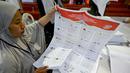 Para staf melipat surat suara pemilihan umum Indonesia 2024 di Gudang Logistik Komisi Pemilihan Umum (KPU) Denpasar, Bali, pada 14 Desember 2023. (SONNY TUMBELAKA/AFP)