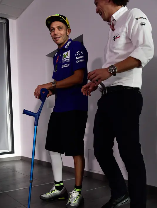 Pembalap tim Yamaha, Valentino Rossi dengan menggunakan kruk menghadiri konferensi pers MotoGP Aragon 2017 di Sirkuit MotorLand, Spanyol, Kamis (21/9). Rossi dinyatakan bisa ambil bagian dalam MotoGP Aragon 2017 pada akhir pekan ini. (JAVIER SORIANO/AFP)