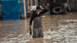 Warga menyelamatkan barangnya saat banjir melanda kota Lima, Peru, Kamis (16/3). Ribuan jiwa di Peru telah jadi korban dan genangan air menyebarkan wabah demam berdarah.(AP Photo / Rodrigo Abd)