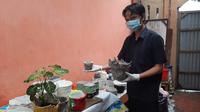 Choirul Anwar menunjukan hasil karyanya kerajinan pot bunga dari limbah popok bayi (Hermawan Arifianto/Liputan6.com)