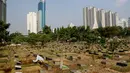 Pekerja tengah membersihkan area makam di TPU Karet Bivak, Jakarta, Kamis (2/10/14). (Liputan6.Com/Faizal Fanani)