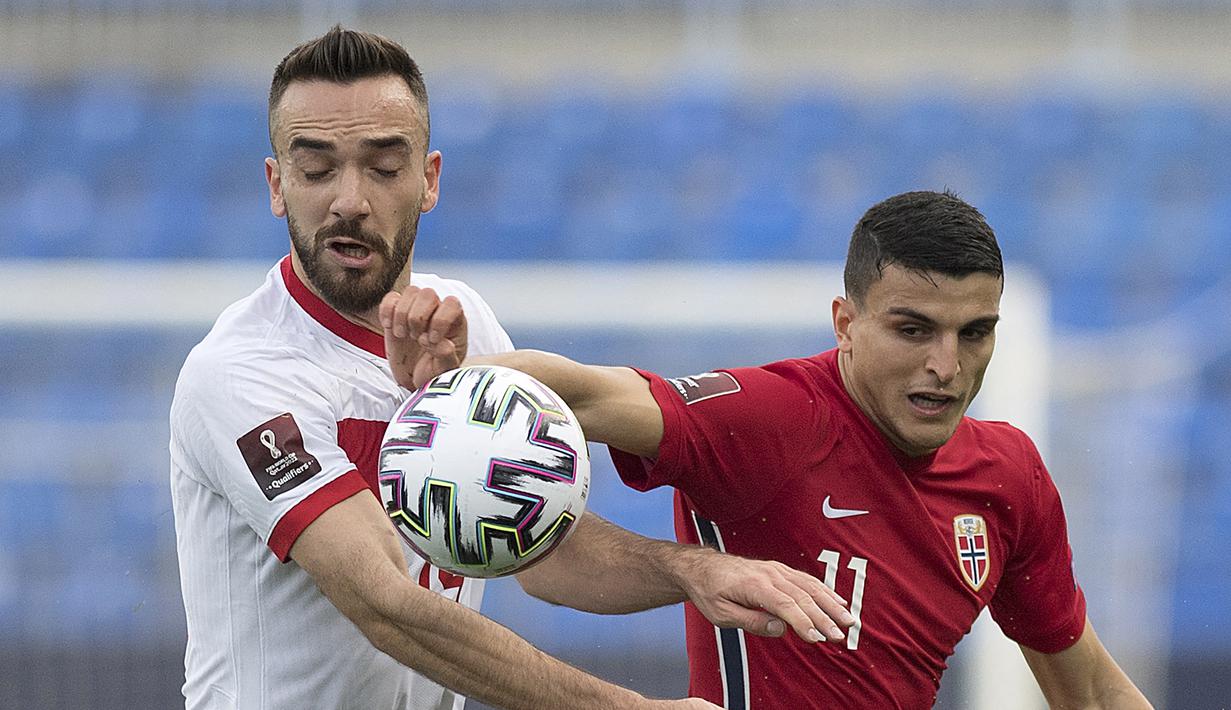 Striker Turki, Kenan Karaman (kanan) berebut bola dengan gelandang Norwegia, Mohamed Elyounoussi dalam laga Kualifikasi Piala Dunia 2022 Zona Eropa Grup G di La Rosaleda Stadium, Malaga, Sabtu (27/3/2021). Turki menang 3-0 atas Norwegia. (AFP/Jorge Guerrero)