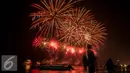 Pengunjung berfoto dengan latar belakang kembang api saat malam pergantian tahun 2017 di Pantai Lagoon, Ancol, Jakarta (1/1). Ribuan warga yang memadati kawasan tersebut tak henti-hentinya meletupkan kembang api ke udara. (Liputan6.com/Gempur M. Surya)