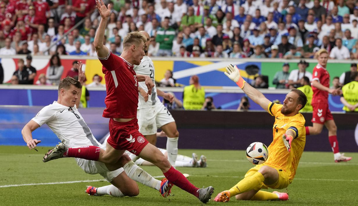 Kiper Timnas Slovenia, Jan Oblak berhasil memblok tendangan dari jarak dekat striker Timnas Denmark, Rasmus Hojlund (tengah) pada laga Grup C Euro 2024 di MHPArena, Stuttgart, Jerman, Minggu (16/6/2024). (AP Photo/Antonio Calanni)