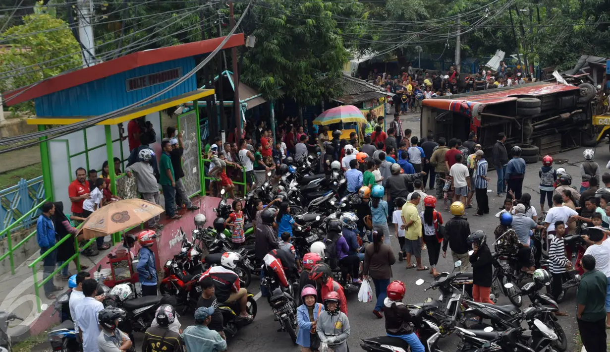 Sejumlah orang berkumpul di lokasi kecelakaan Bus Trans Semarang yang menabrak pangkalan ojek di Jalan Sultan Agung, Semarang, Minggu (17/7). Bus sarat penumpang itu diduga mengalami rem blong. (Liputan6.com/Gholib)