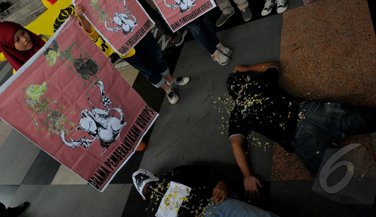 Sebuah poster bergambar tikus turut dipajang mahasiswa saat aksi teaterikal di depan gedung KPK, Jakarta, Kamis (5/3/2015). Aksi tersebut menuntut pemerintah untuk segera menghentikan kriminalisasi KPK (Liputan6.com/Faisal R Syam)