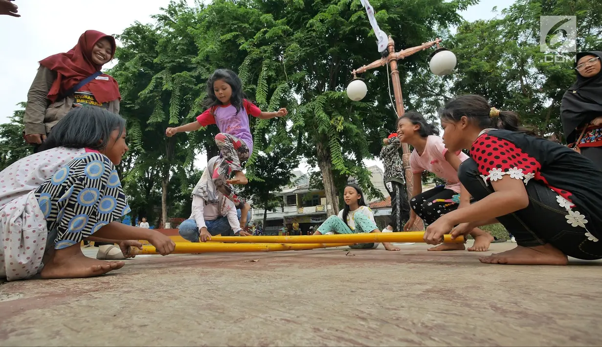 Anak-anak bermain permainan tradisional rangku alu di RPTRA Melati Duri Pulo, Jakarta, Sabtu (13/10). Traditional Games Returns (TGR) mengampanyekan permainan tradisional dengan mengusung tema "Millenials". (Liputan6.com/Herman Zakharia)