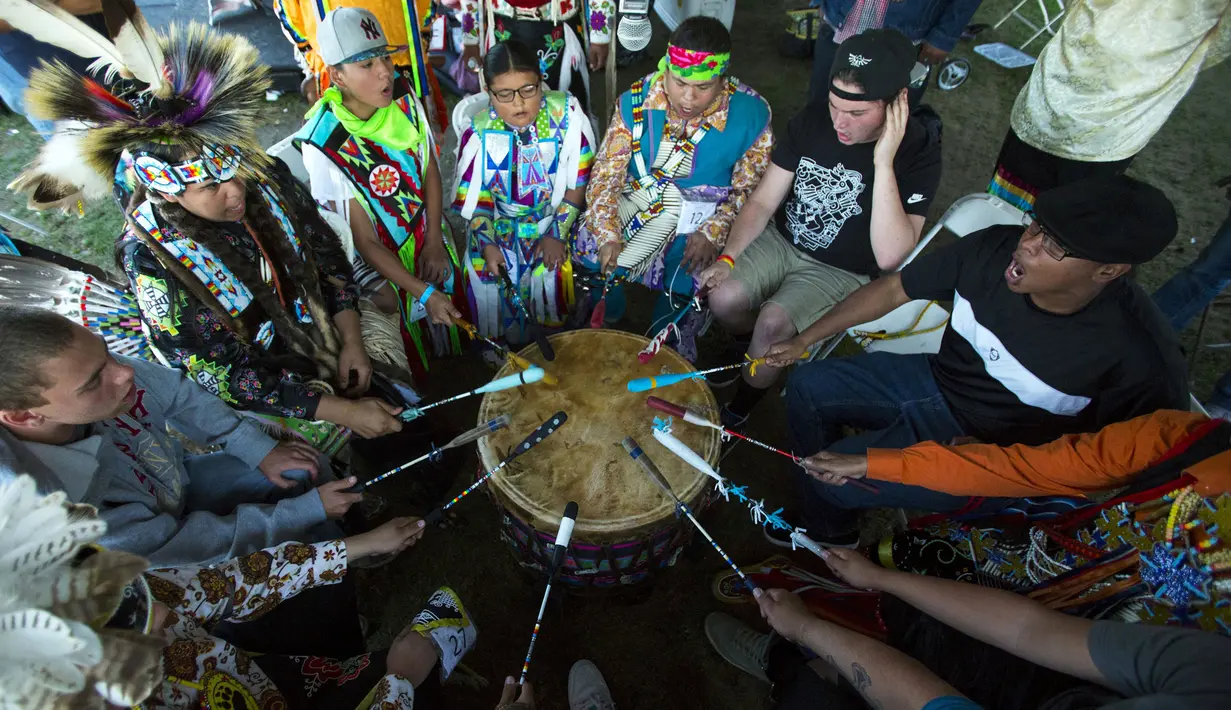Pengunjung memainkan drum dalam perayaan "pow-wow" pada Hari Festival Masyarakat Pribumi di Randalls Island, New York, Minggu (11/10/2015). Kedatangan Christopher Colombus dianggap awal penjajahan bagi penduduk asli Amerika. (REUTERS/Eduardo Munoz)