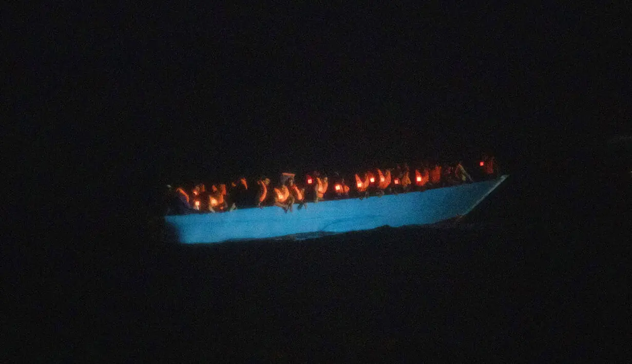Imigran menunggu petolongan LSM Spanyol Open Arms di Laut Mediterania, Selasa (8/9/2020). Puluhan imigran termasuk wanita dan anak-anak asal Mesir, Maroko, Somalia, dan Sierra Leone menghabiskan lebih dari 20 jam saat melarikan diri dari Libya dengan kapal kayu. (AP Photo/Santi Palacios)