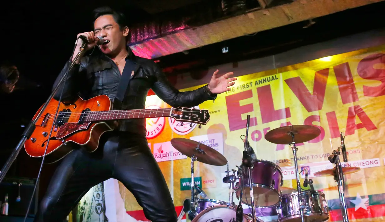 Peserta dari Filipina, Jun Espinosa saat final kontes menyanyikan lagu Elvis Persley di Manila, Filipina, Sabtu (19/8). Lomba yang pertama di Asia ini untuk mengenang 40 tahun kematian legenda Rock 'n Roll, Elvis Persley. (AP Photo/Bullit Marquez)