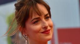 Dakota Johnson tersenyum di depan penggemarnya saat menghadiri pemutaran film "'Black Mass" di Festival Film Venesia ke-72 di Italia, (5/9/2015). Bintang film 'The Fifty Shades Of Grey' itu tampil sensual tanpa mengunakan bra. (AFP PHOTO/GIUSEPPE CACACE)